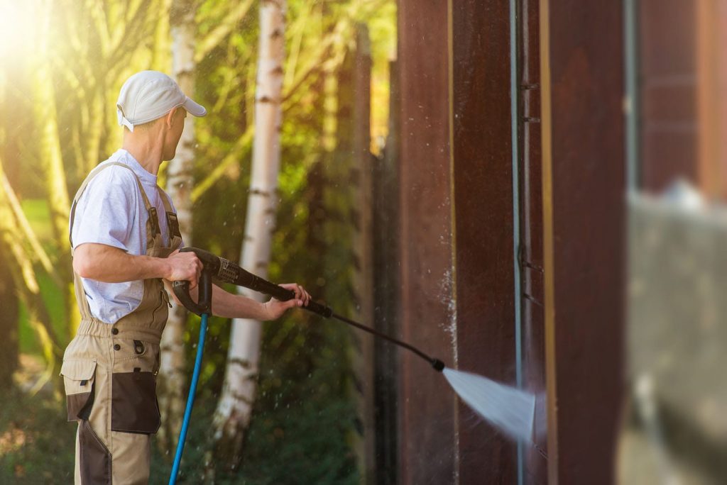 A powerwasher hosing down a house during Spring Cleaning.