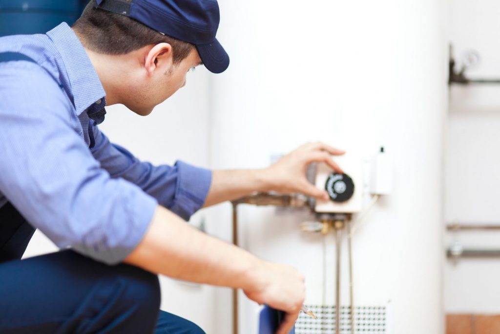 An HVAC technician conducting water heater maintenance