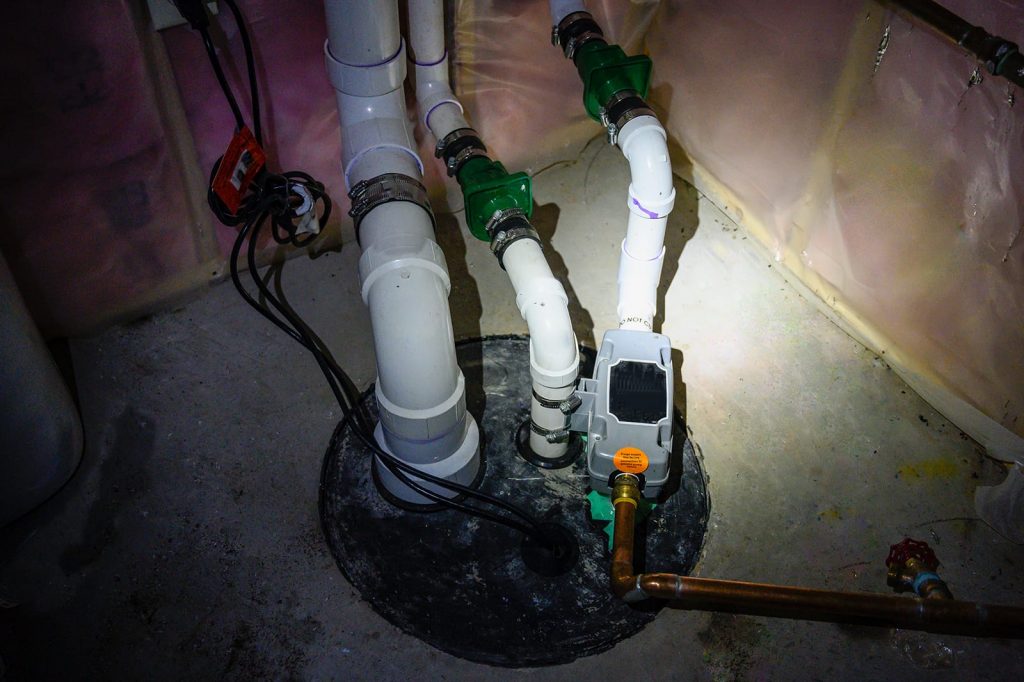 Sump pump problems can create havoc in your basement. A sump pump lit by flashlight.
