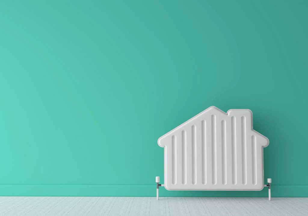 A radiator shaped like a house against a green wall. Winter plumbing checklist