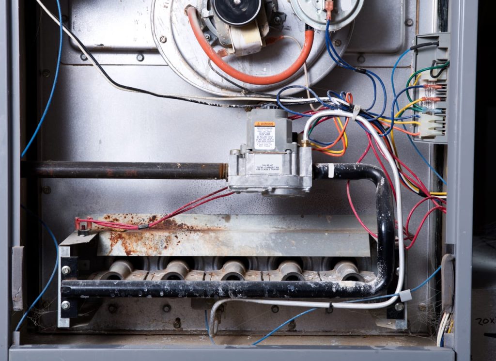 The inside of a home furnace that badly needs a tune-up